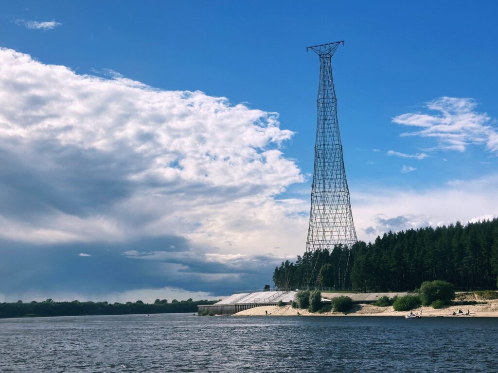 Вид на берег реки с антенной и зелеными деревьями.