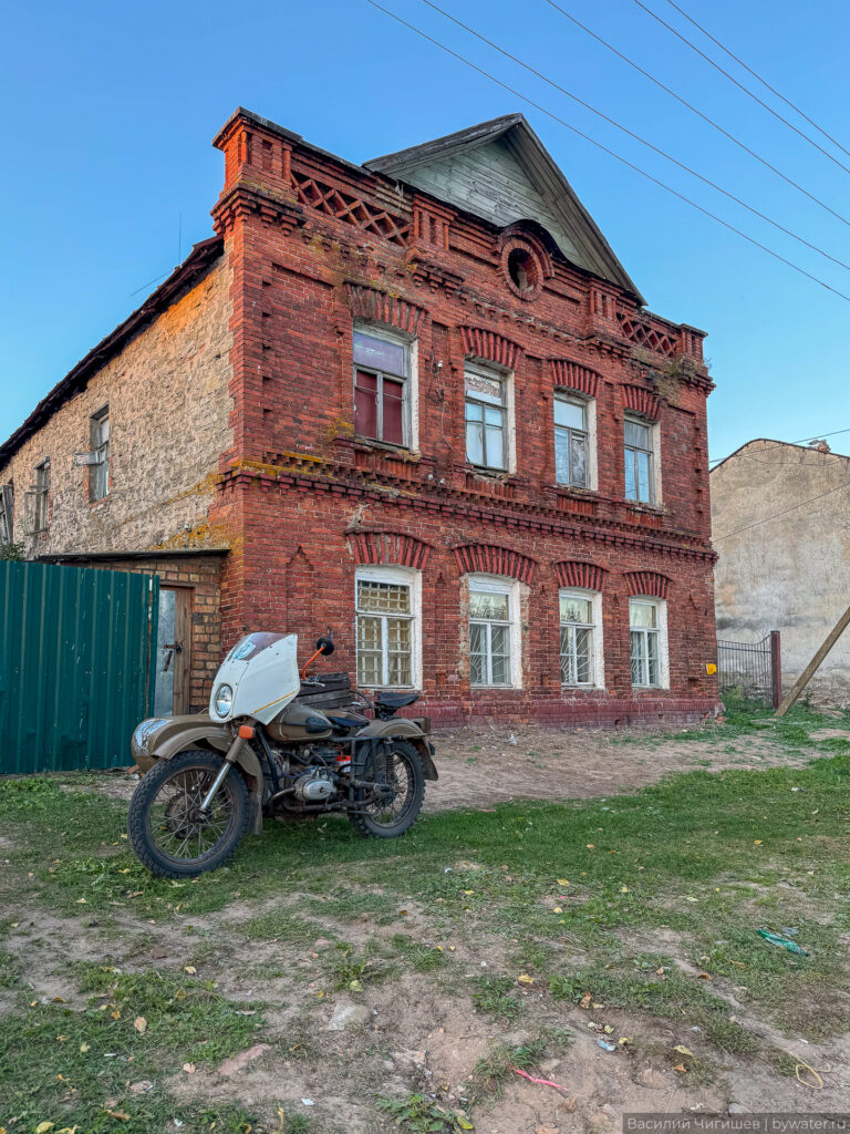 Старинное здание из красного кирпича с мотоциклом.