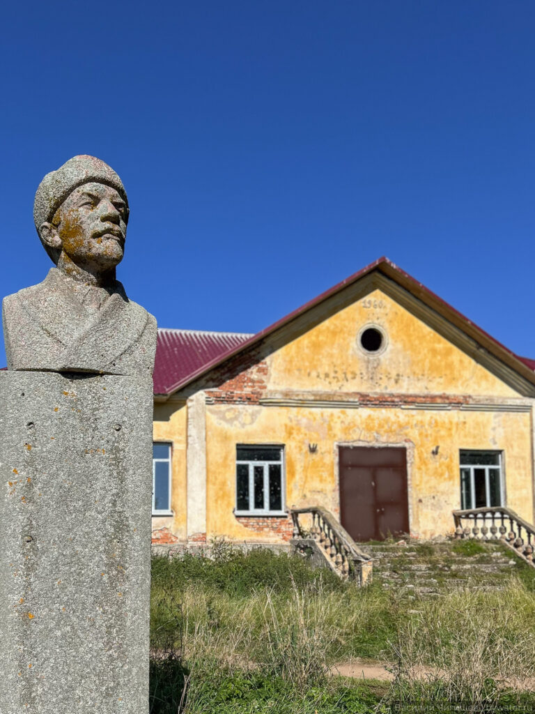 Памятник у старого речного вокзала на фоне голубого неба.