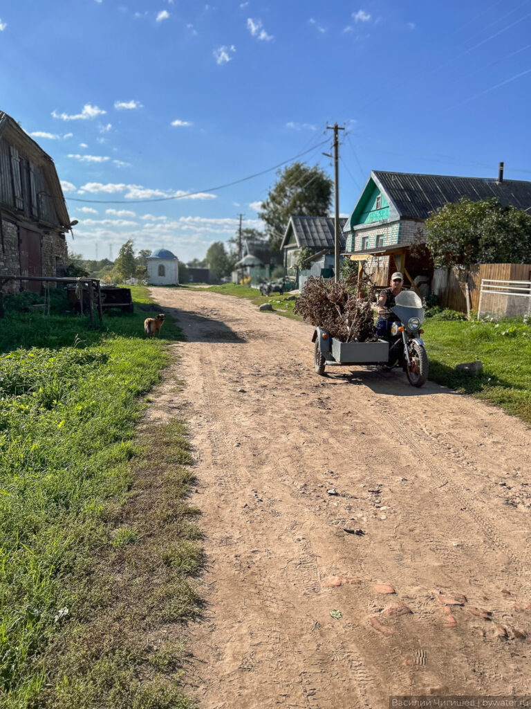 Мотоцикл с прицепом на сельской дороге в России.