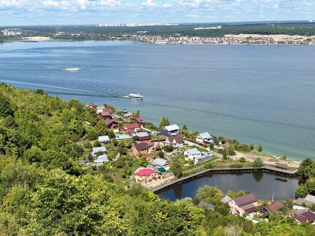 Теплоход на реке, вид на берега и дома.