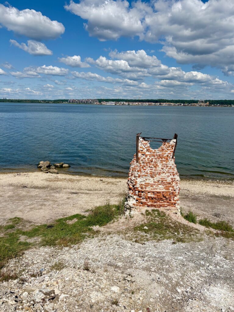 Руины на берегу реки, задний план с городом.