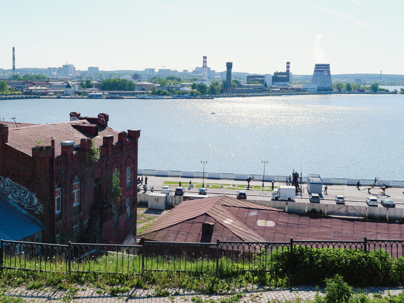 Панорамный вид на реку и набережную с причалом.