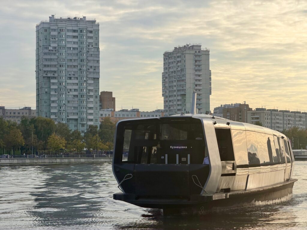 Речной теплоход рядом с набережной в городе.