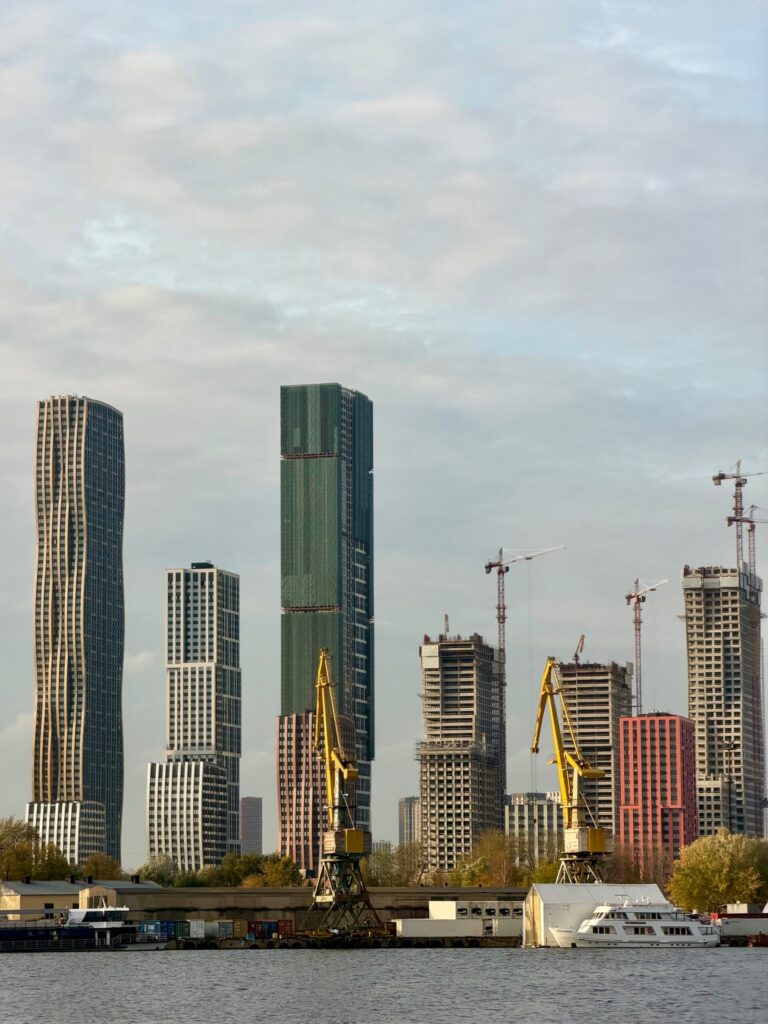 Современный порт с грузовыми кранами и рекой.